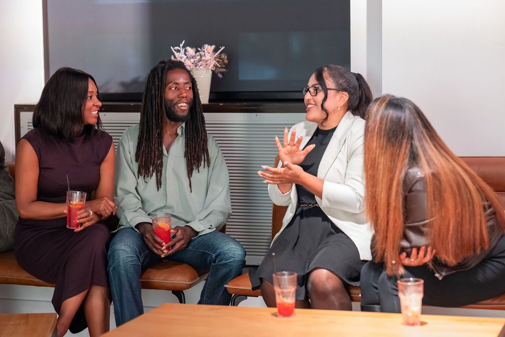 Members laughing together on a sofa at the Unify Social 2026